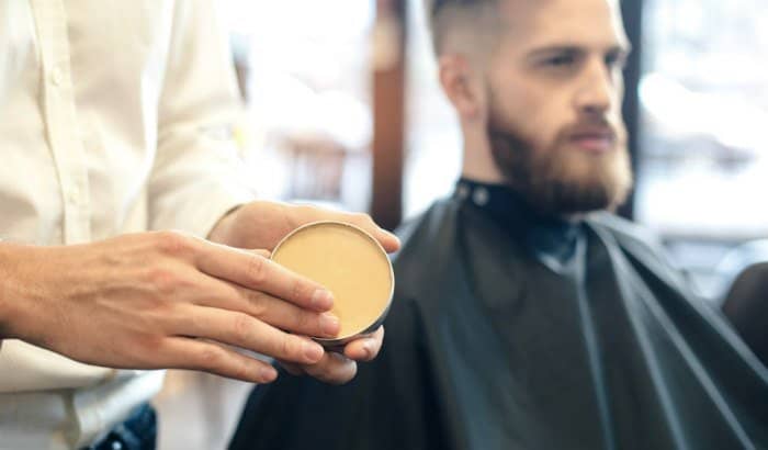 barber using beard wax on client