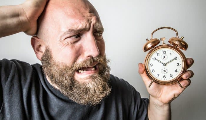 bearded man looking at a clock