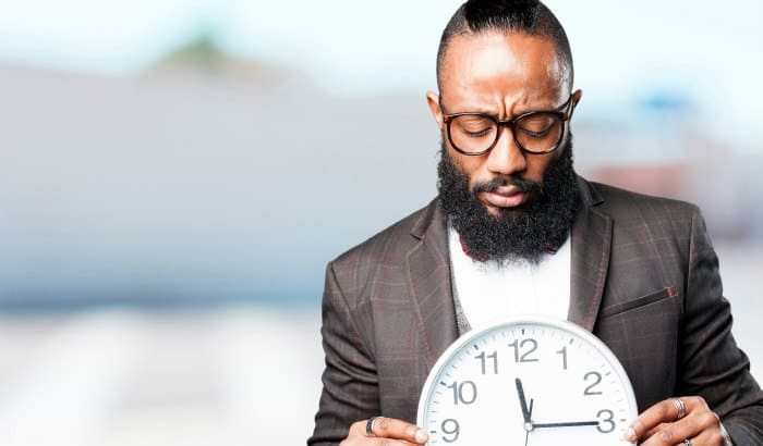 bearded man looking at a clock