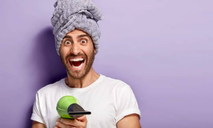 bearded man pointing a blow dryer