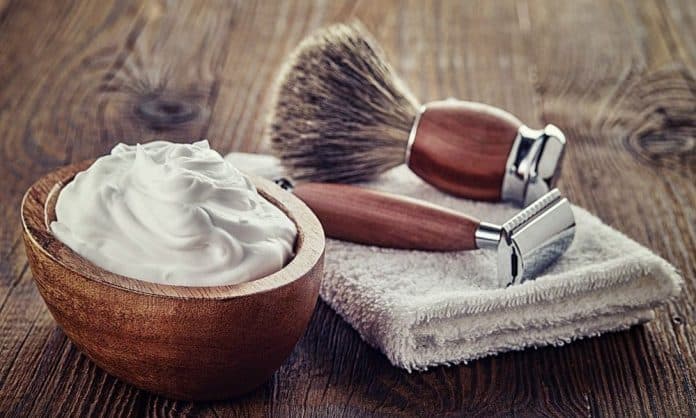 shaving cream and shaving items on a table with a towel