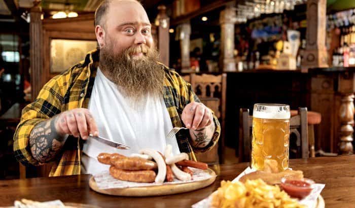 fat bearded man enjoying food