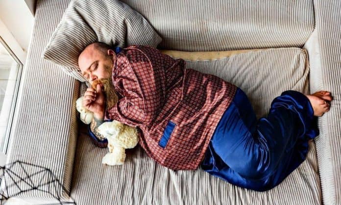 fat man with a soft looking beard sleeping in silky pyjamas