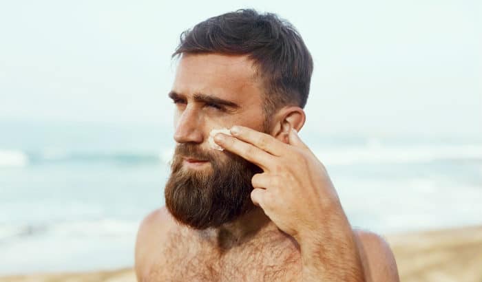 man applying aloe vera lotion to face