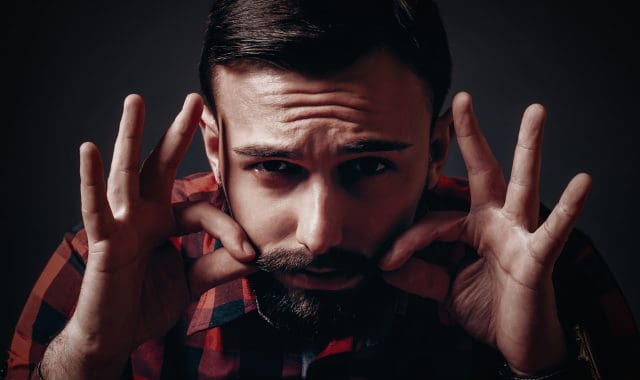 man applying castor oil to his beard