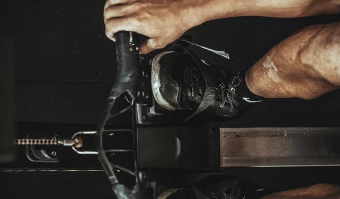 man exercising on rowing machine