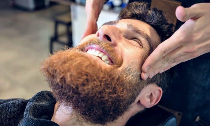 man getting his beard exfoliated