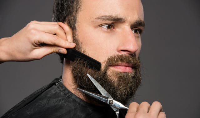 man getting his beard trimmed