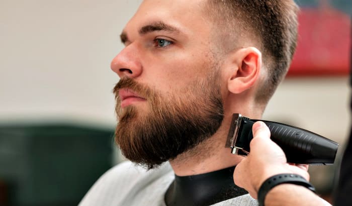 man getting professional beard fade at barbershop