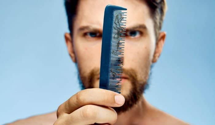 man looking at damaged beard hairs