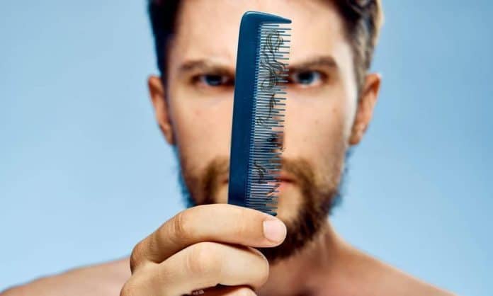 man seeing fallen beard hair on a comb