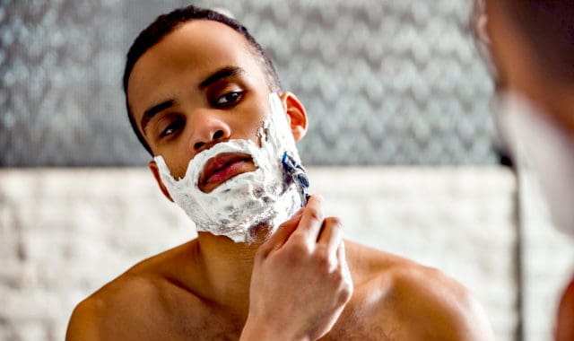 man shaving his facial hair