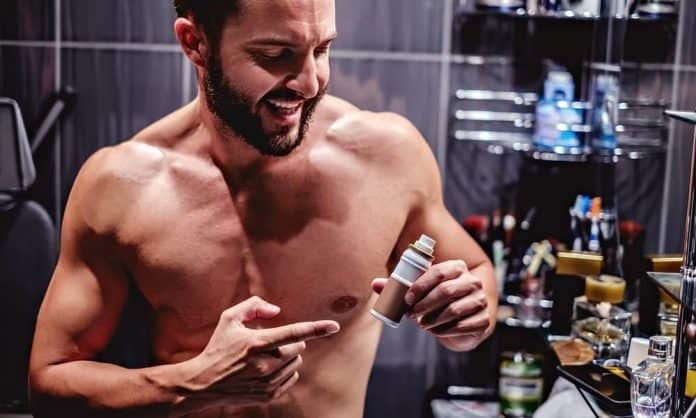 man showing a bottle of beard growth serum