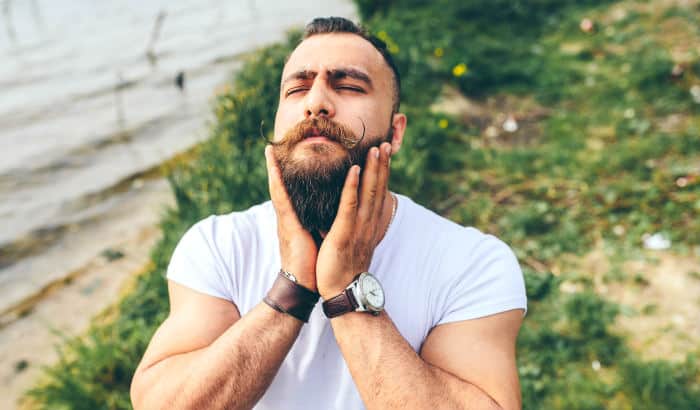 man touching his long beard