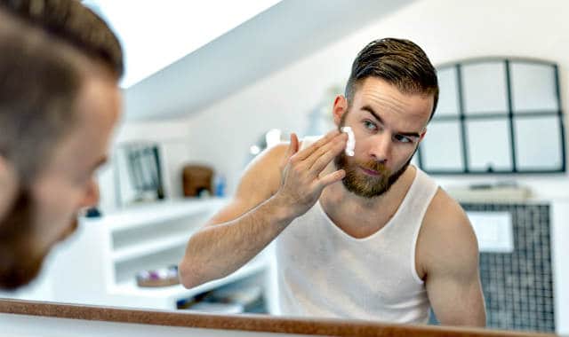 man using a beard moisturizer on his face