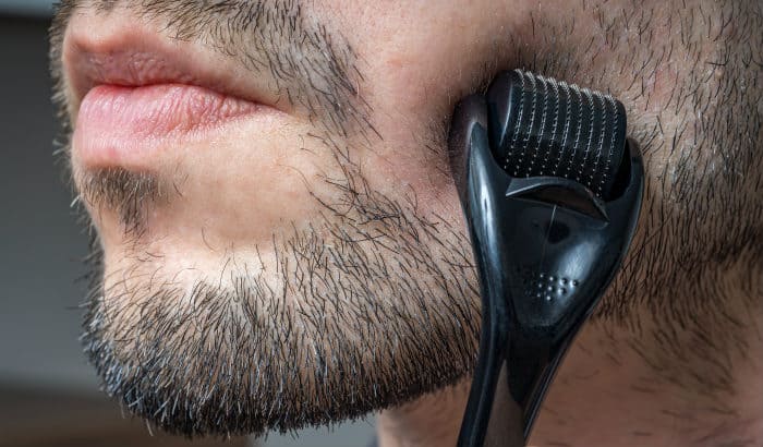 man using beard roller