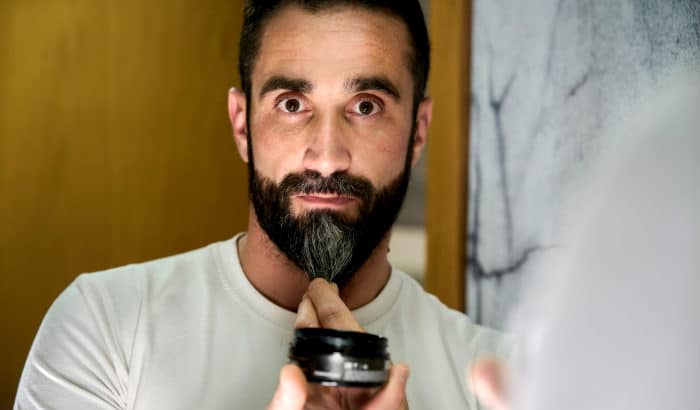 man using darkening beard wax