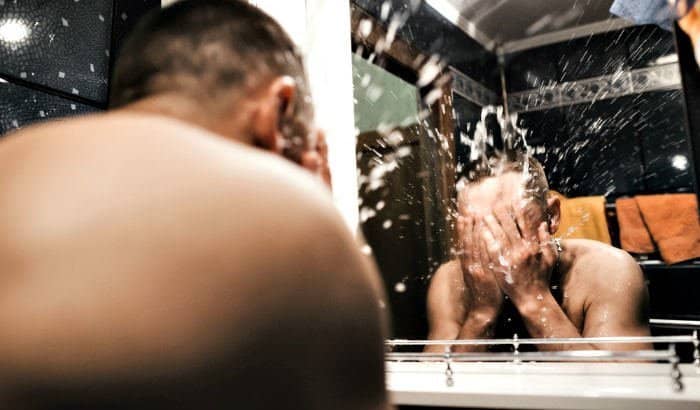 man washing beard over sink