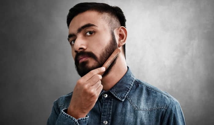 man with dark beard combs it