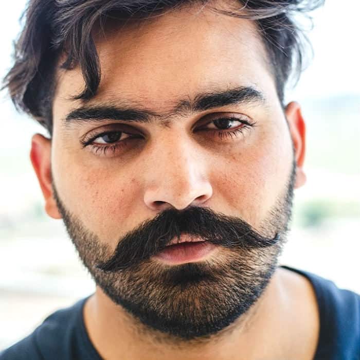 man with heavy stubble and big moustache