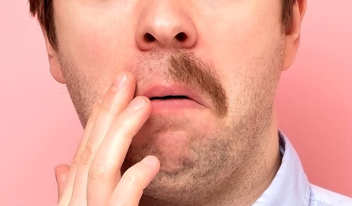 man with mustache half shaved off