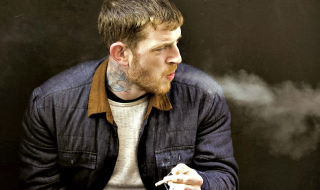 short bearded man smoking a cigarette