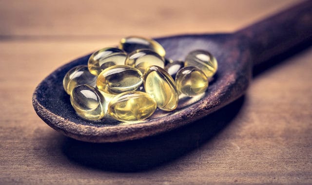 vitamin d capsules in a spoon